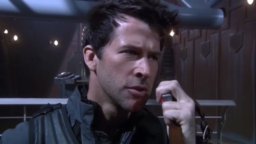 Major John Sheppard (Joe Flanigan) speaks into a radio handset.