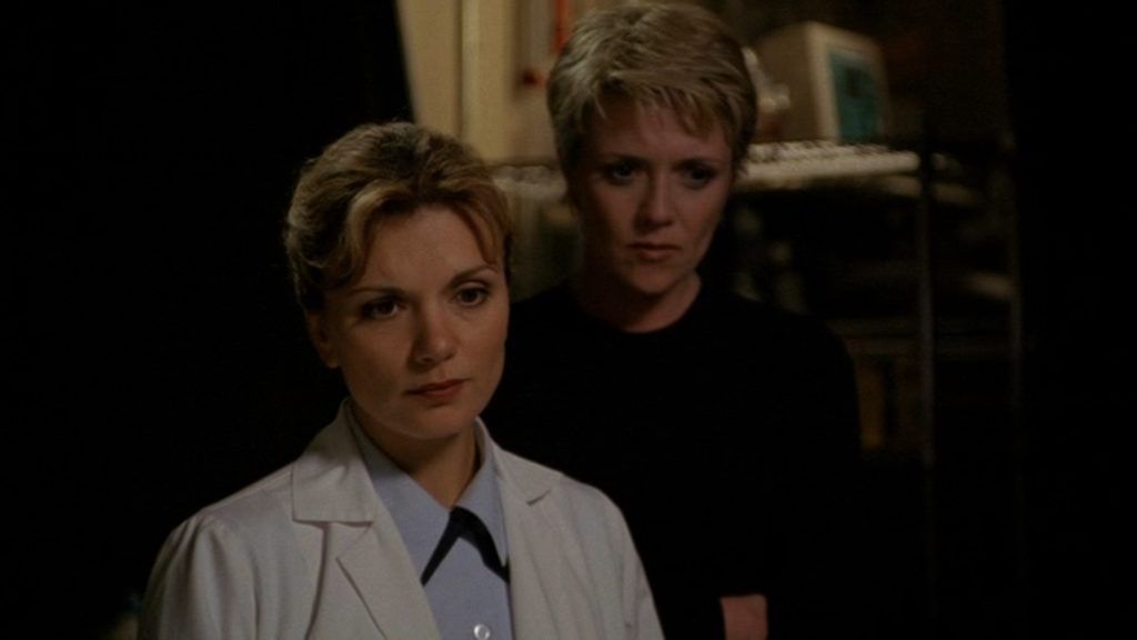 Samantha Carter (Amanda Tapping) looks over Janet Fraiser (Teryl Rothery)’s shoulder.