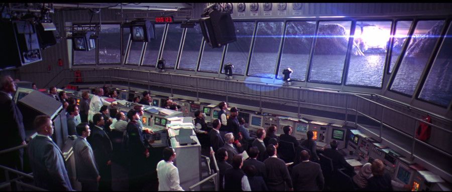 A crowd gathers in the control overlooking the ocean as the alien device is lit up.