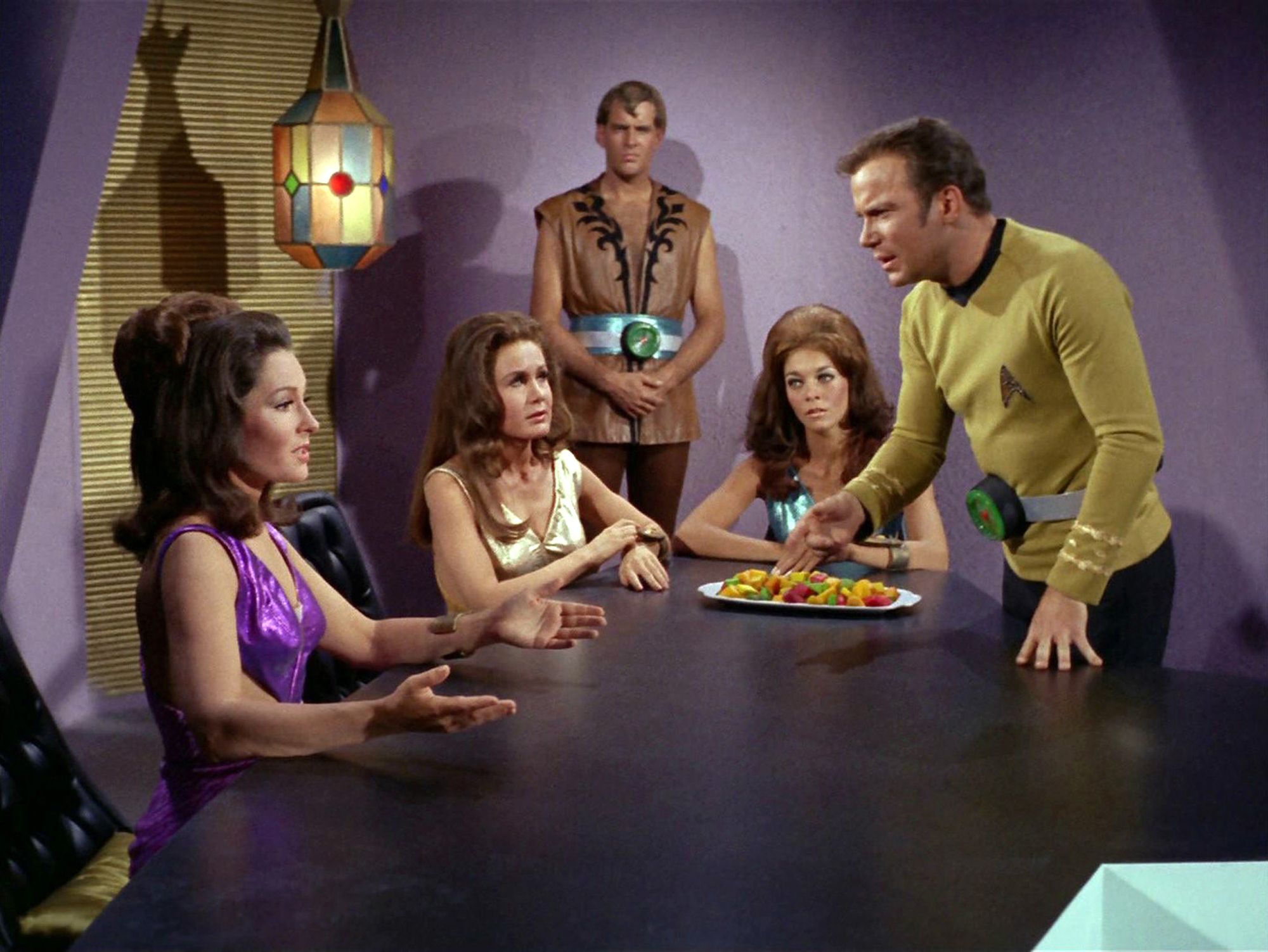 Captain James T. Kirk (William Shatner) stands over a table.