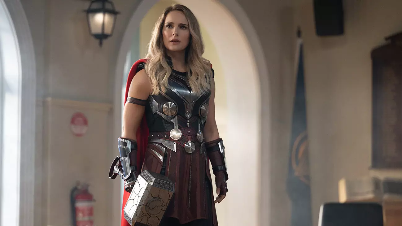 Jane Foster (Natalie Portman) wears the armor and brandishes the hammer of Thor.