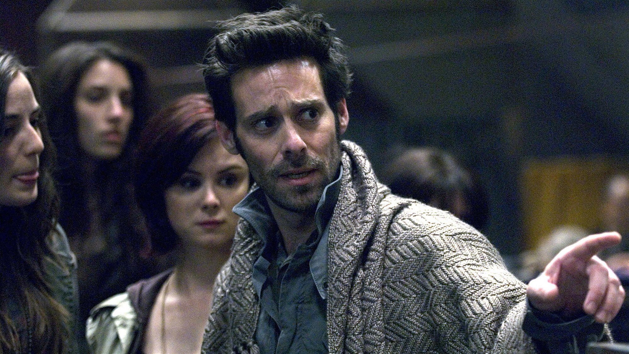 Gaius Baltar (James Callis) has a blanket over his shoulders.