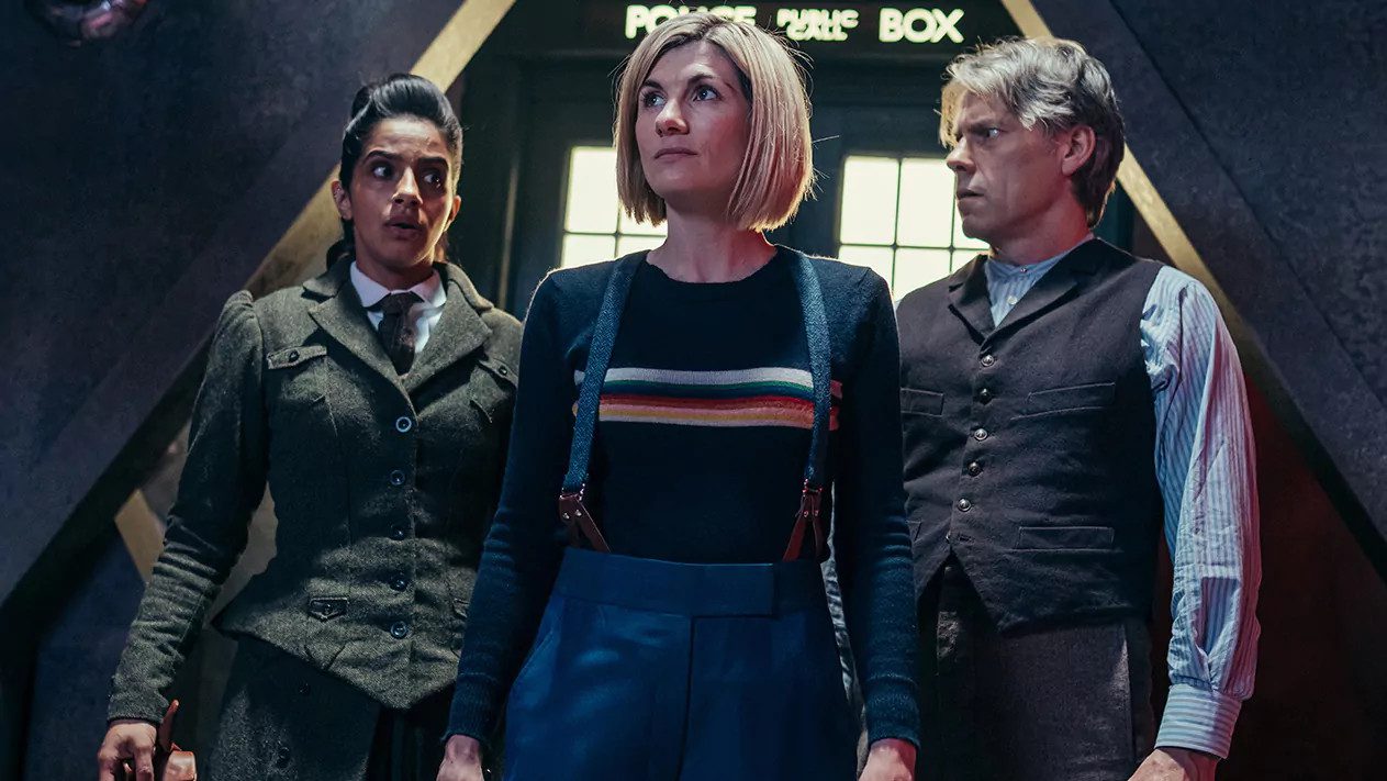 Yaz (Mandip Gill) and Dan (John Bishop) wear Victorian dress and stand either side of the Doctor (Jodie Whittaker).