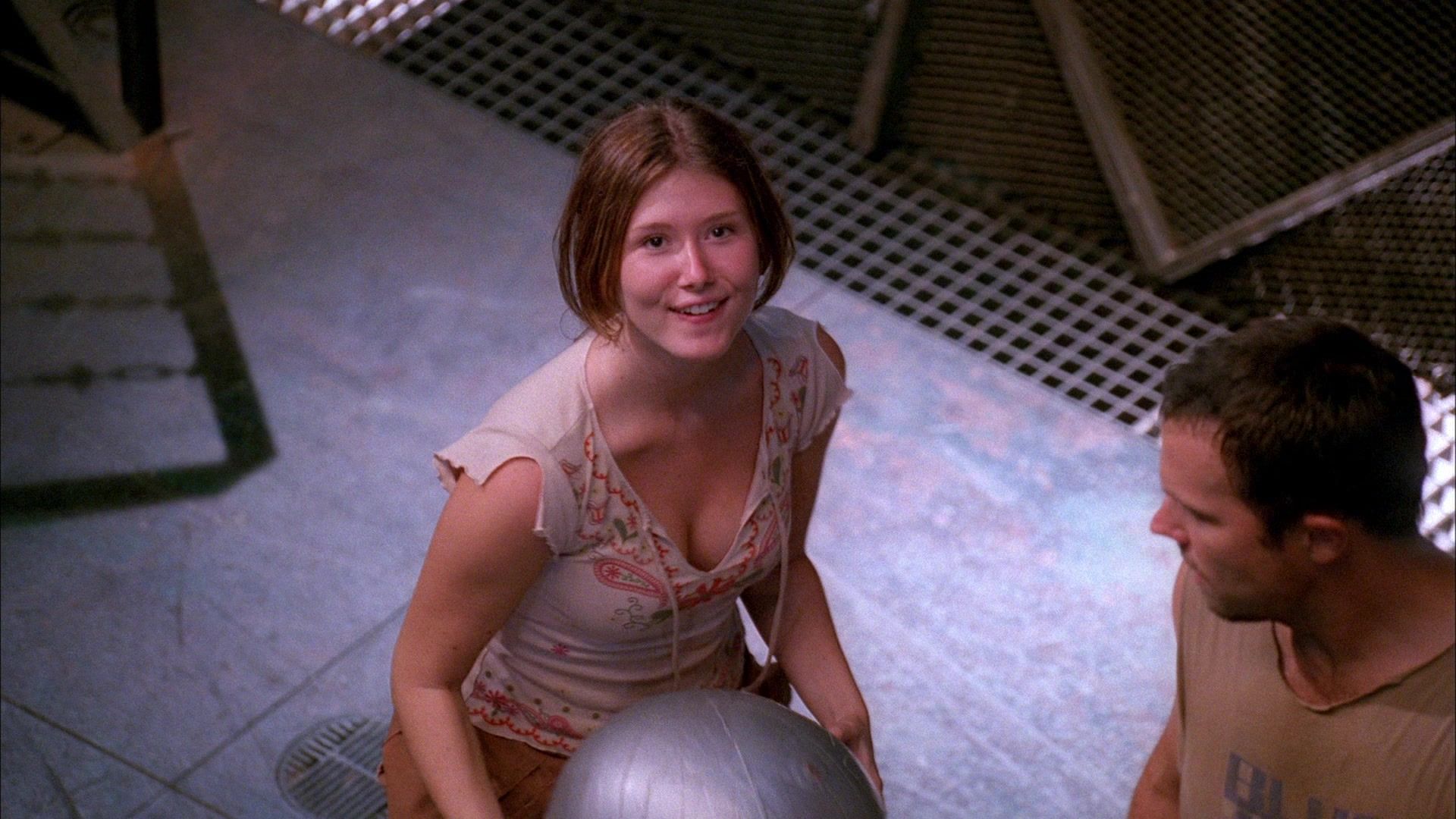 Kaylee looks up towards the camera, she's holding an oversized silver ball.