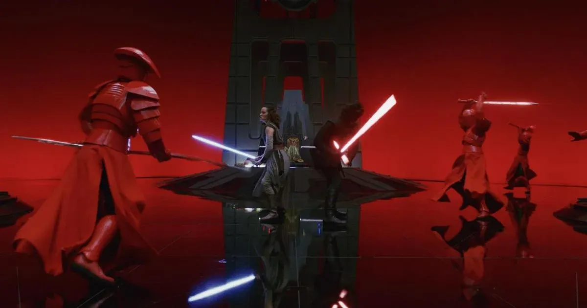 Kylo Ren (Adam Driver) and Rey (Daisy Ridley) stand back to back with their lightsabers drawn as red-armoured guards close in on them. Behind them is Snoke’s empty throne.