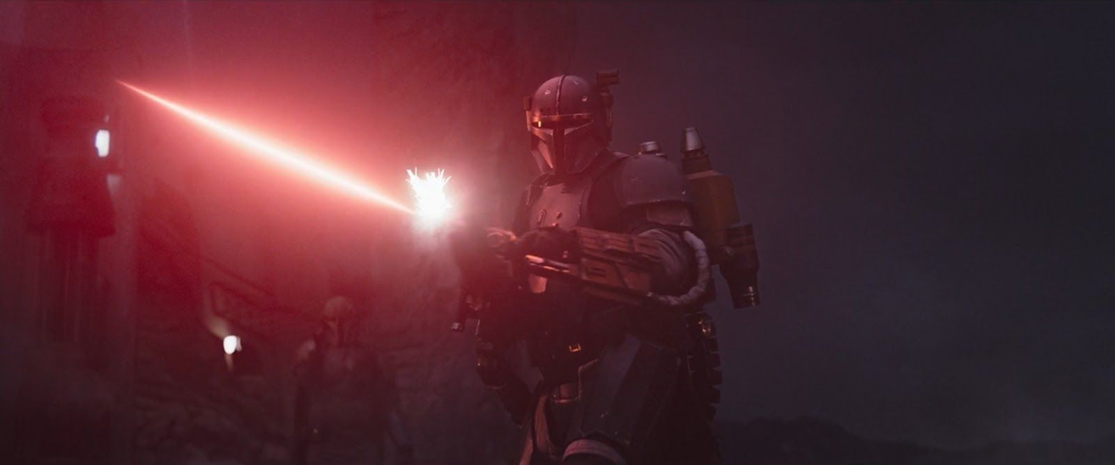 A heavily armored Mandalorian opens fire with a heavy blaster, the barrel glowing red.