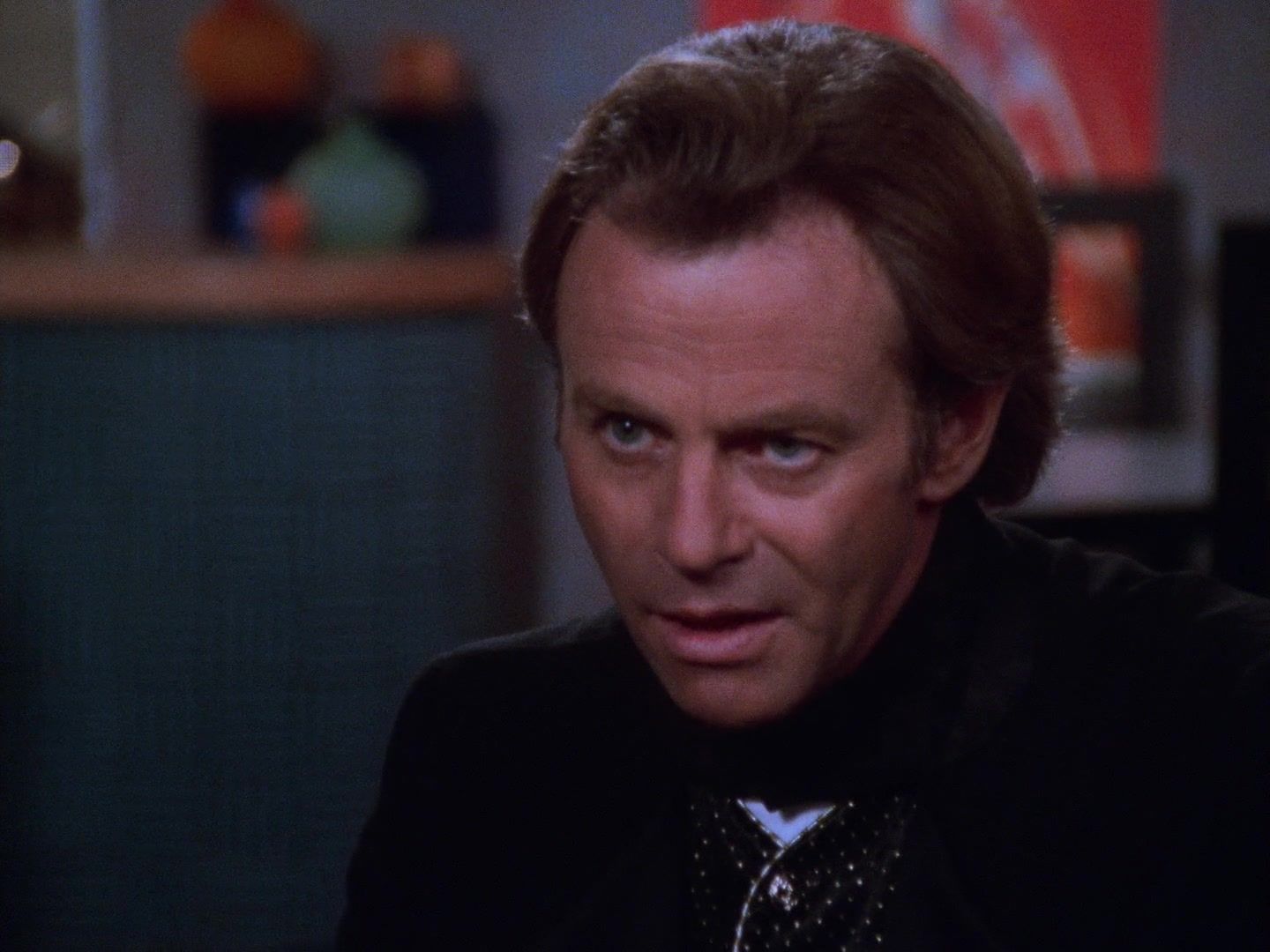 Malcolm Biggs (Tristan Rogers) wearing a black suit.