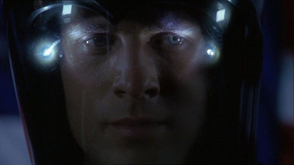 John Crichton (Ben Browder) lit by the lights in his helmet.
