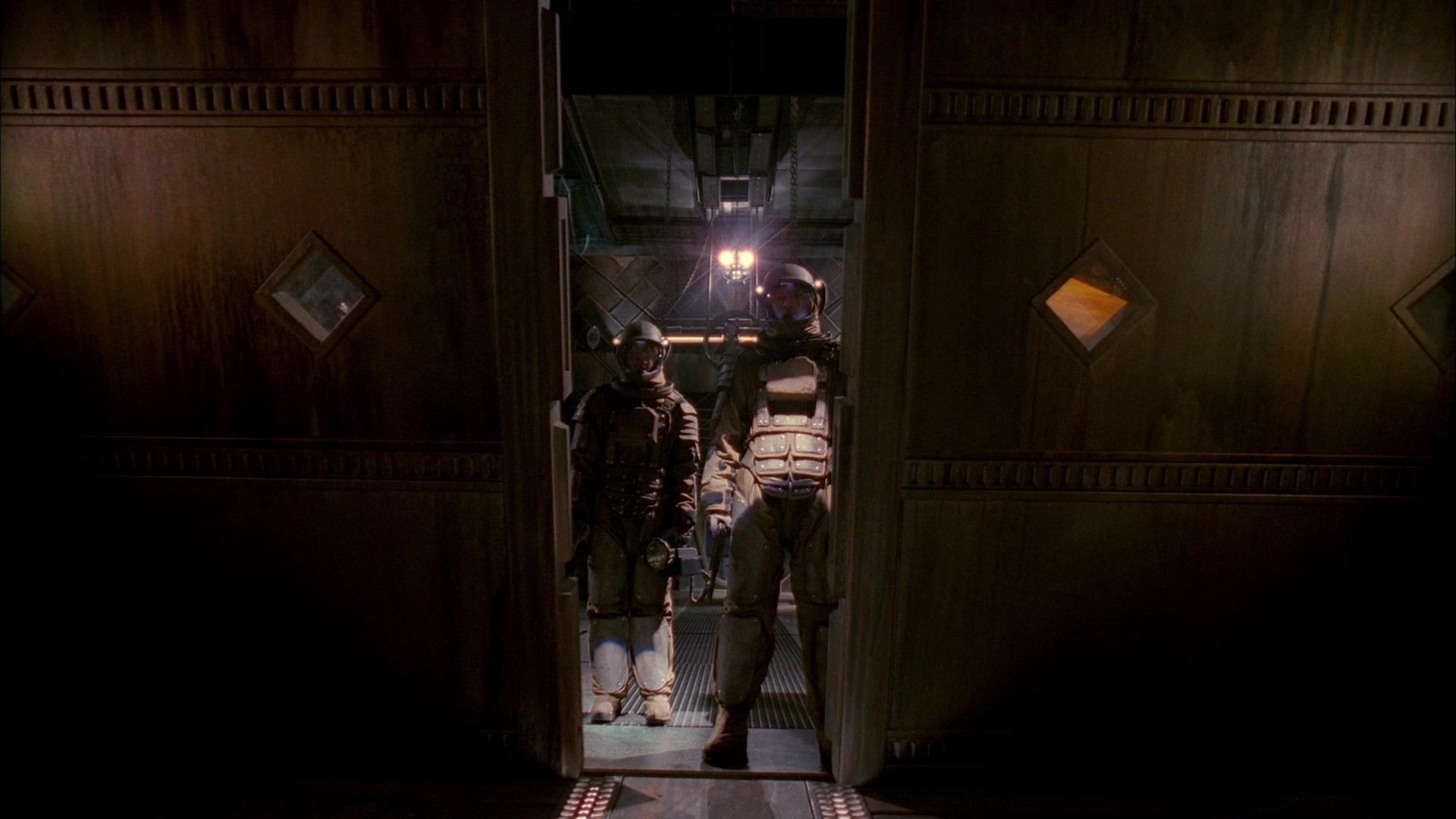 Mal Reynolds (Nathan Fillion) stands in a space suit as the bulkhead doors open.