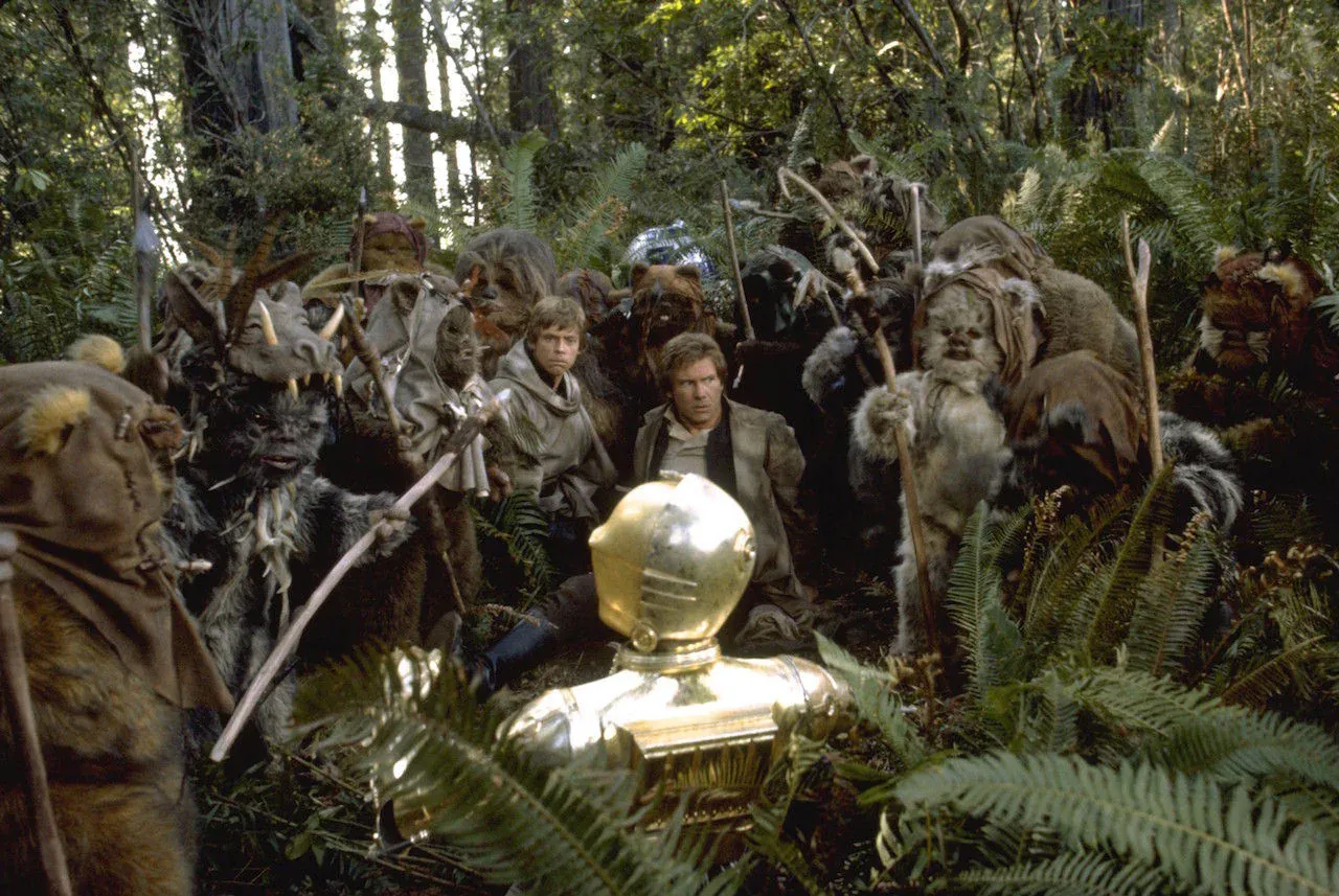 Four Ewoks with Stone Age weapons stand amongst the ferns.