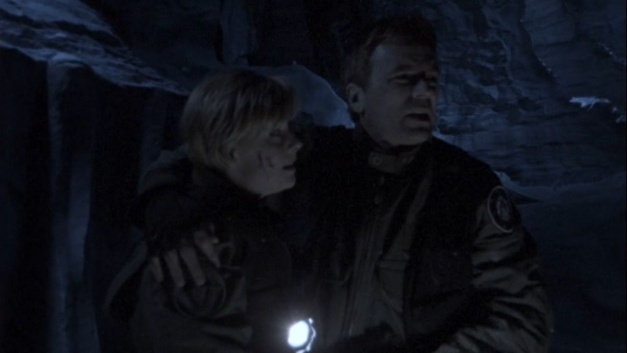 Samantha Carter (Amanda Tapping) supports the wounded Jack O’Neill (Richard Dean Anderson).