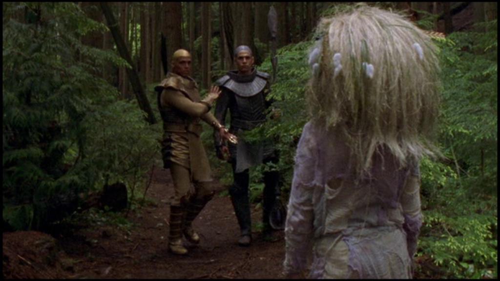 Apophis holds his Serpent Guard back as the Nox child Nafrayu appears ahead of them on the path through the forest.