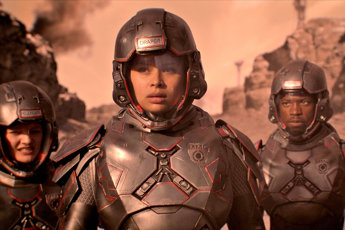Bobbie Draper, flanked by two other marines in grey power armor.