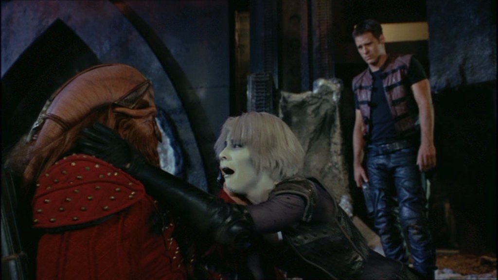 Chiana (Gigi Edgley) looks distraught as she speaks to the wounded D‘Argo (Anthony Simcoe).