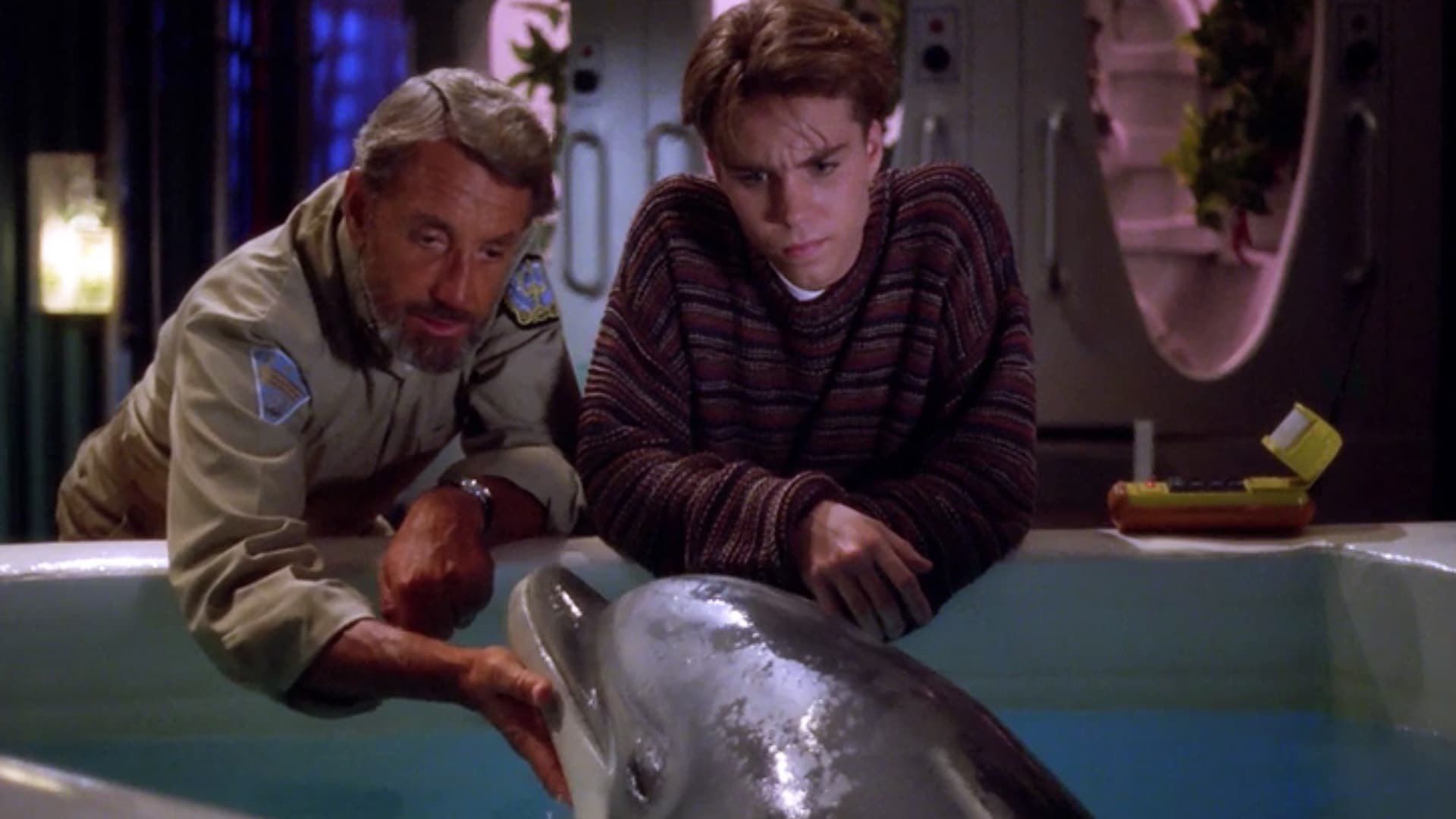 Captain Nathan Bridger (Roy Scheider) and Lucas Wolenczak (Jonathan Brandis) talk to Darwin the dolphin.