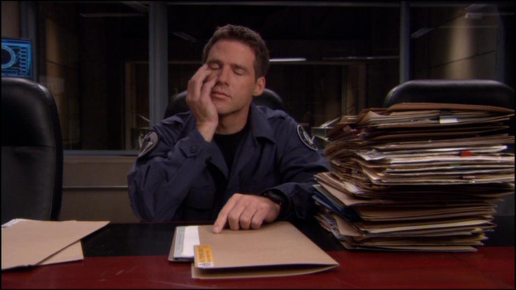 Cameron Mitchell (Ben Browder) closes his eyes and rests his face in his hands.