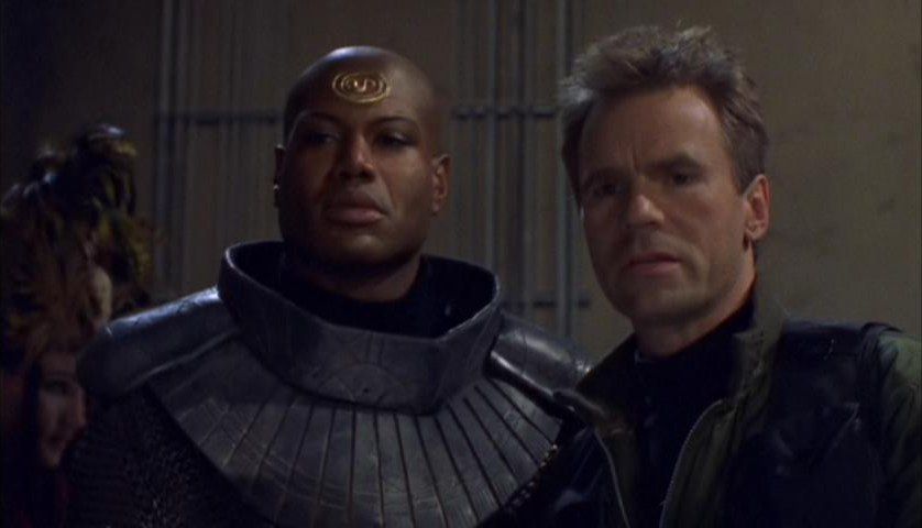 Teal’c (Chris Judge) and Jack O’Neill  (Richard Dean Anderson) stand in the gateroom at the climax of Stargate SG-1's ‘Children of the Gods: The Final Cut’.