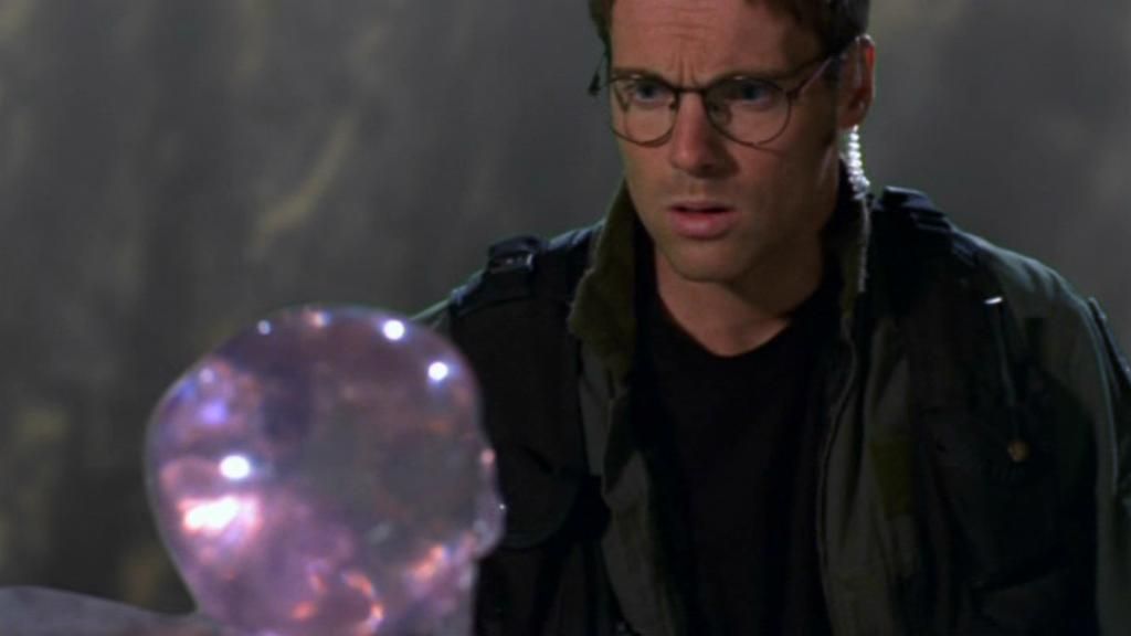 Daniel Jackson (Michael Shanks) looks down at the semi-transparent purple crystal skull.