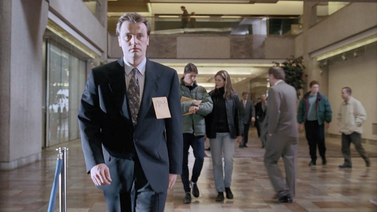 Foo Fighters frontman Dave Grohl and his wife Jennifer Youngblood are visible behind a suited man who walks towards the camera.