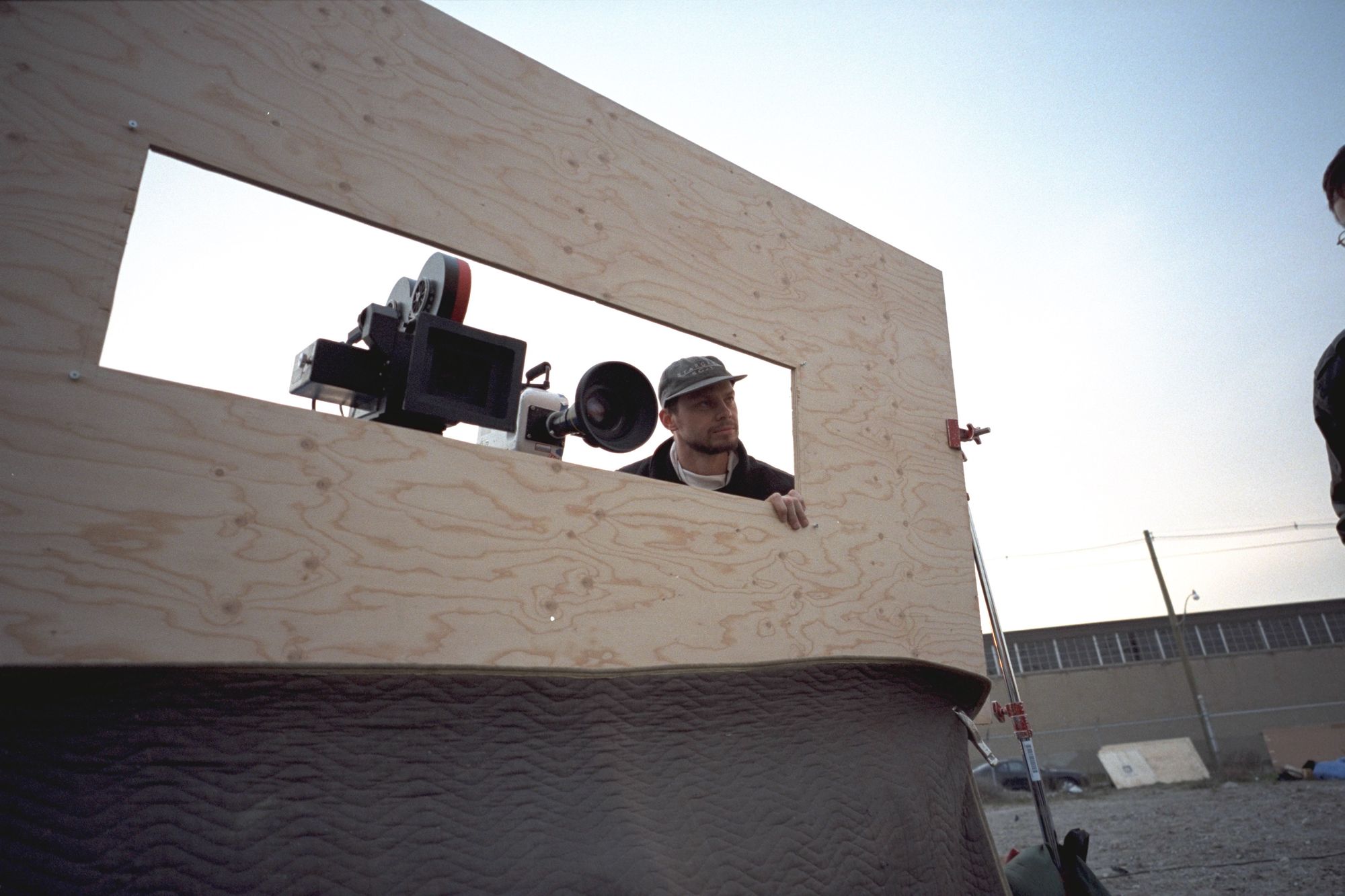 Stargate SG-1 VFX supervisor John Gajdecki peers out from behind a plywood screen with a space for the camera.