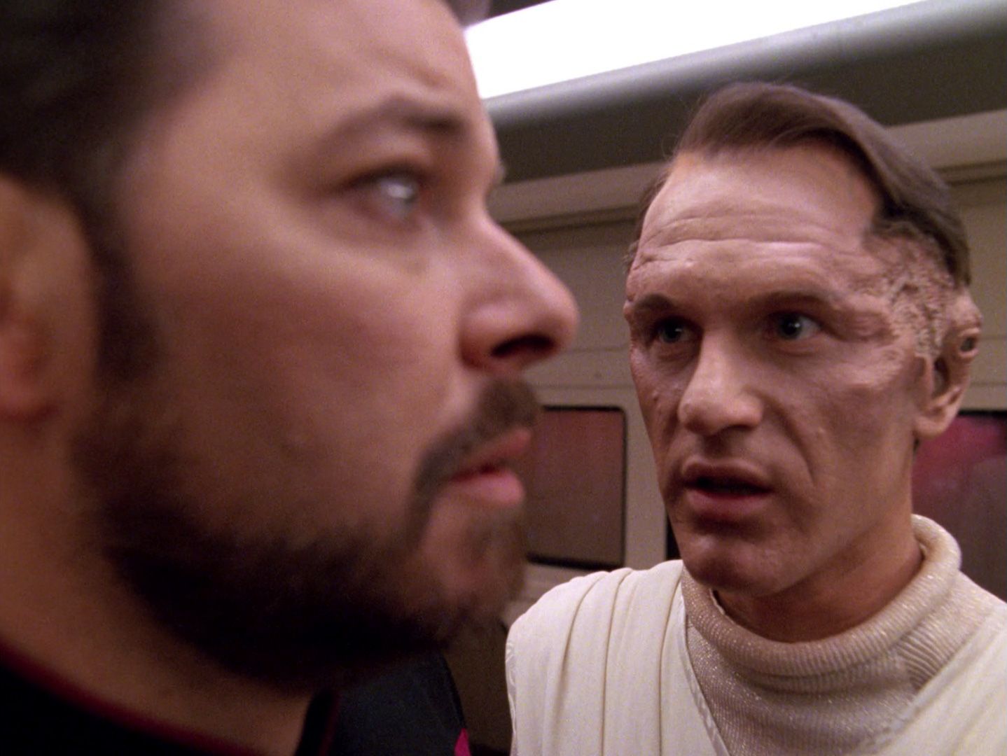 Commander Will Riker (Jonathan Frakes) looks blank as Jev (Ben Lemon) speaks to him.