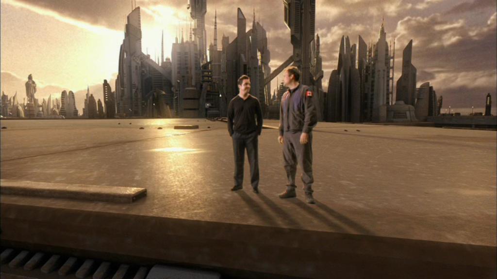 Rodney McKay (David Hewlett) and Carson Beckett (Paul McGillion) in the Stargate Atlantis episode ‘Sunday’. Beckett is fading out, revealing that McKay has been talking to himself. Atlantis is visible in the background.