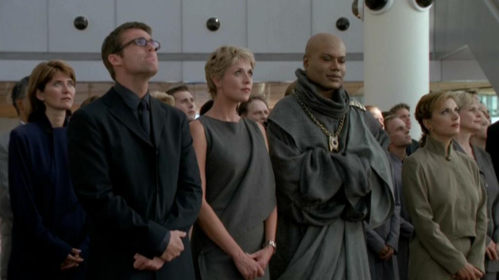 Daniel Jackson (Michael Shanks), Samantha Carter (Amanda Tapping), and Teal’c (Christopher Judge) wearing formal attire.