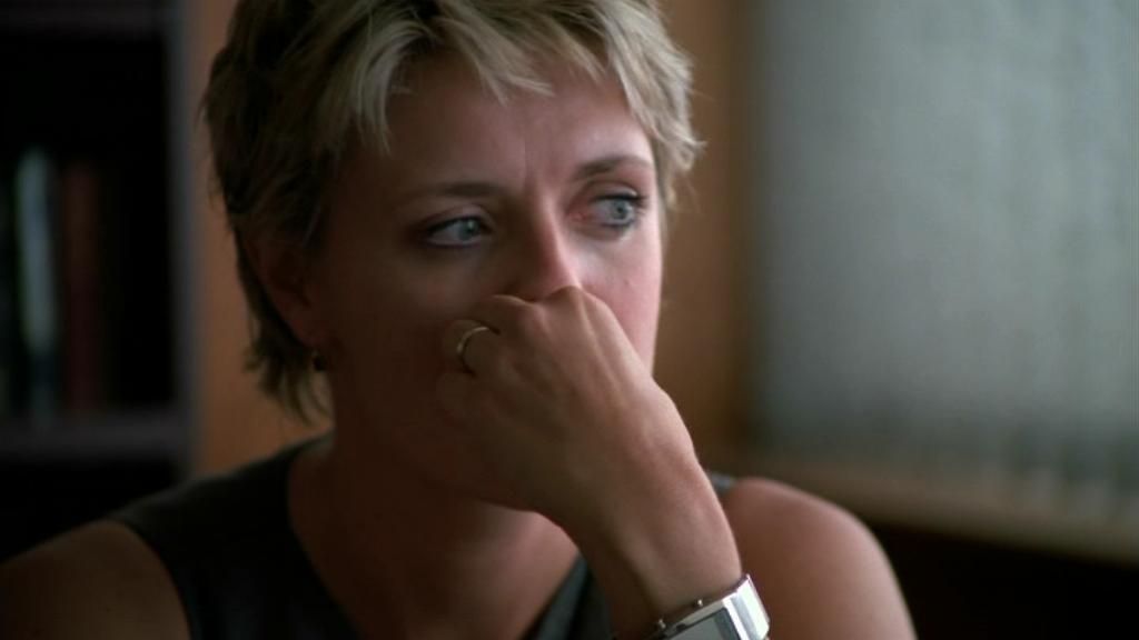 Samantha Carter (Amanda Tapping) looks away, her hand covering her mouth.