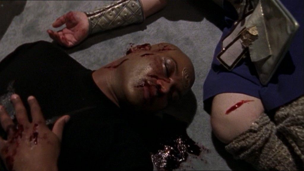 A bloodied Teal'c lies unconscious next to Cronus.