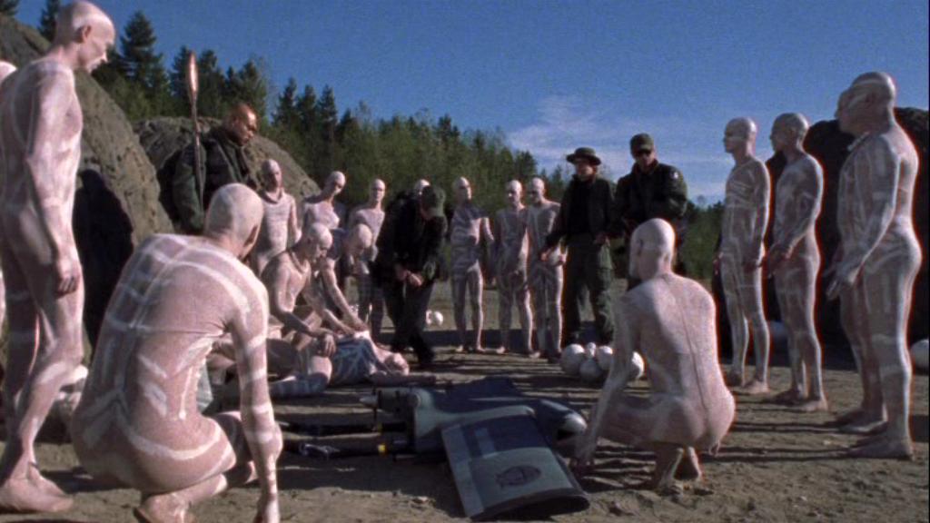 SG-1 are surrounded by the inhabitants of the alien planet in the Stargate SG-1 episode 'One False Step'..