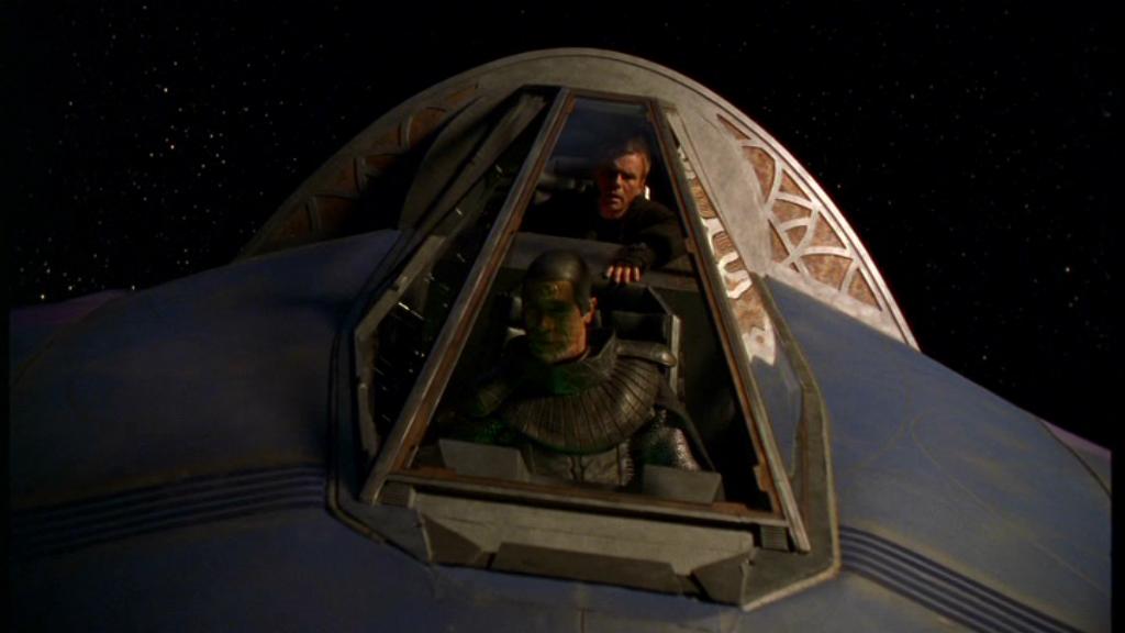 Jack O’Neill (Richard Dean Anderson) and Master Bra’tac (Tony Amendola) viewed through a cockpit window.