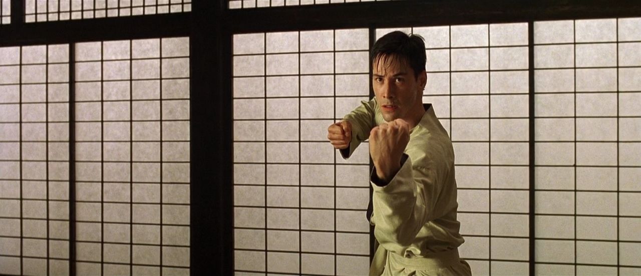 Neo (Keanu Reeves) assumes a fighting stance.