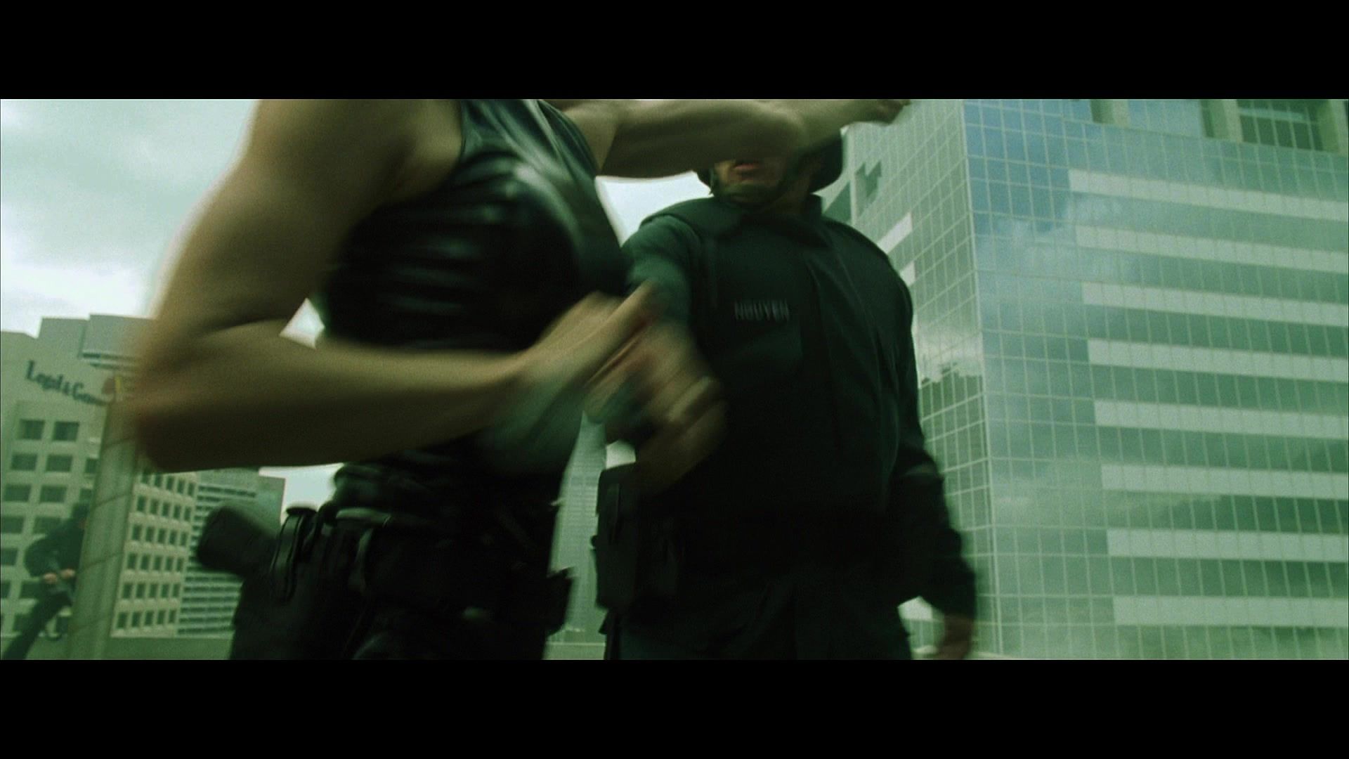 Trinity (Carrie-Anne Moss) punches a SWAT guy.