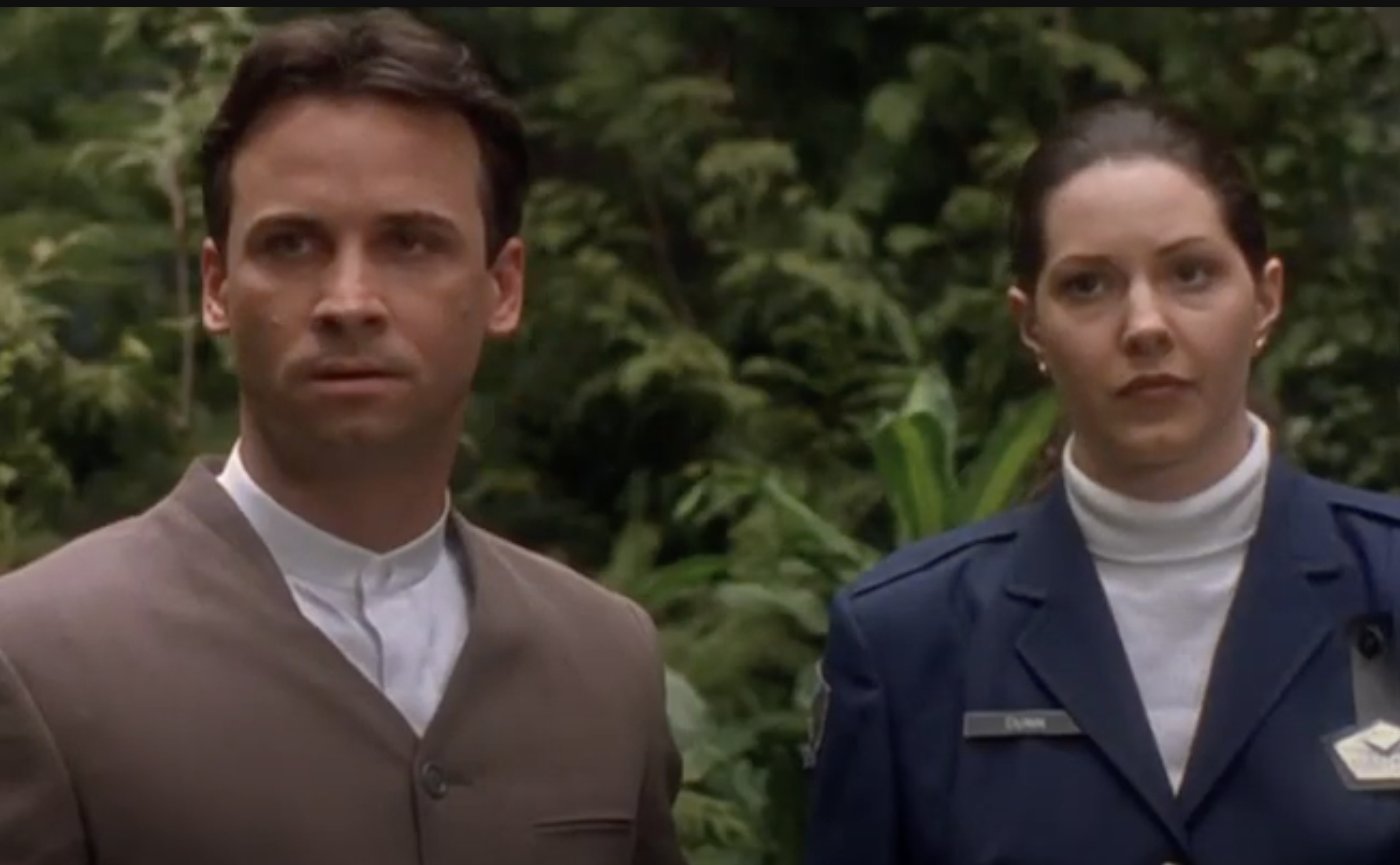 Professor George Ernst (Colin Cunningham) wears a grey suit and white shirt with nehru collar.