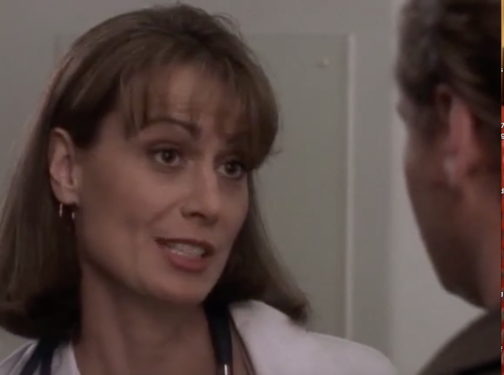 Dr. Christina Markham (Mel Harris) in a white coat with a stephoscope around her neck.