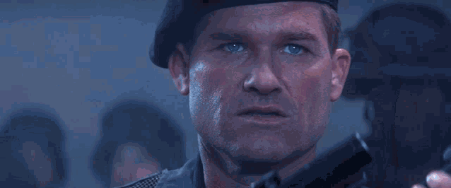 Jack O'Neill and soldiers step towards the surface of the Stargate, the light flickers over their faces.