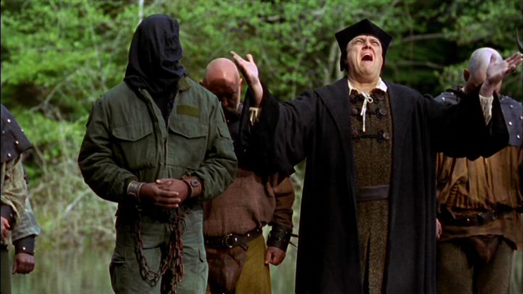 The Canon, played by A.C. Peterson, appears to be shouting with guards at his back in in the Stargate SG-1 episode 'Demons'. He's wearing a hat.