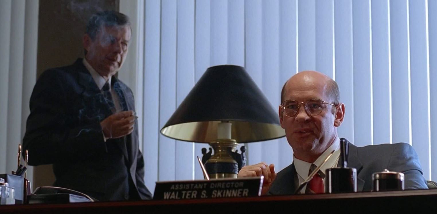 Assistant Director Walter Skinner (Mitch Pileggi) and Cigarette-Smoking Man (William B. Davis) pile the pressure onto Mulder (David Duchovny) in The X-Files episode ‘Tooms’ (S1, Ep21). ‘Tooms’ was the first episode to feature Assistant Director Walter Skinner and the first in which Cigarette-Smoking Man speaks. | 20th Century Fox, 1994.